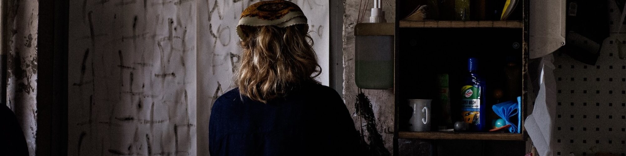 Foto av ett rum. person i förgrunden står med ryggen vänd mot betraktaren.