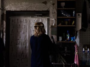 Foto av ett rum. person i förgrunden står med ryggen vänd mot betraktaren.